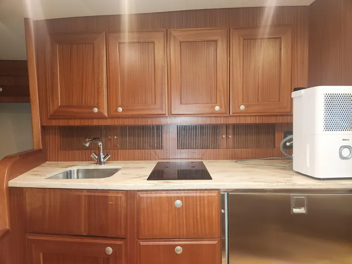  Yacht Photos Pics Wooden kitchen interior of 2015 Jupiter 41 SB yacht with sink and appliances.