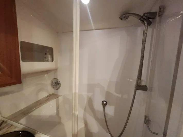  Yacht Photos Pics Shower area in 2015 Jupiter 41 SB boat with handheld showerhead and built-in shelf.