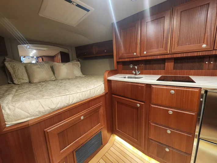  Yacht Photos Pics Luxurious interior of 2015 Jupiter 41 SB yacht with wood cabinetry and cozy sleeping area.