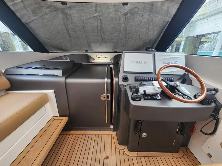  Yacht Photos Pics Helm of 2015 Jupiter 41 SB boat with Garmin navigation system and wooden steering wheel.