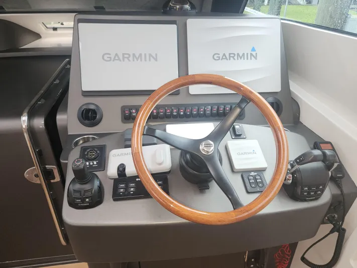  Yacht Photos Pics Helm of 2015 Jupiter 41 SB with Garmin displays and wooden steering wheel.