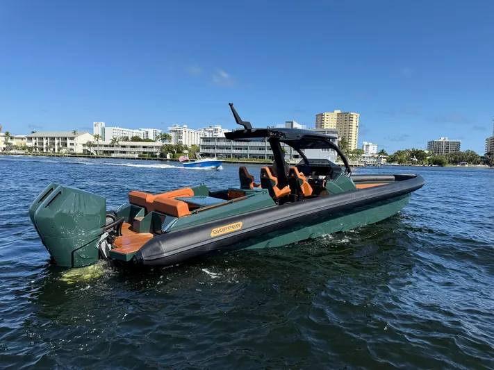 New 2025 Skipper 38 Twin 400 V10 Yacht Photos Pics 2025 Skipper-BSK 38 boat on water, cityscape background, clear blue sky.