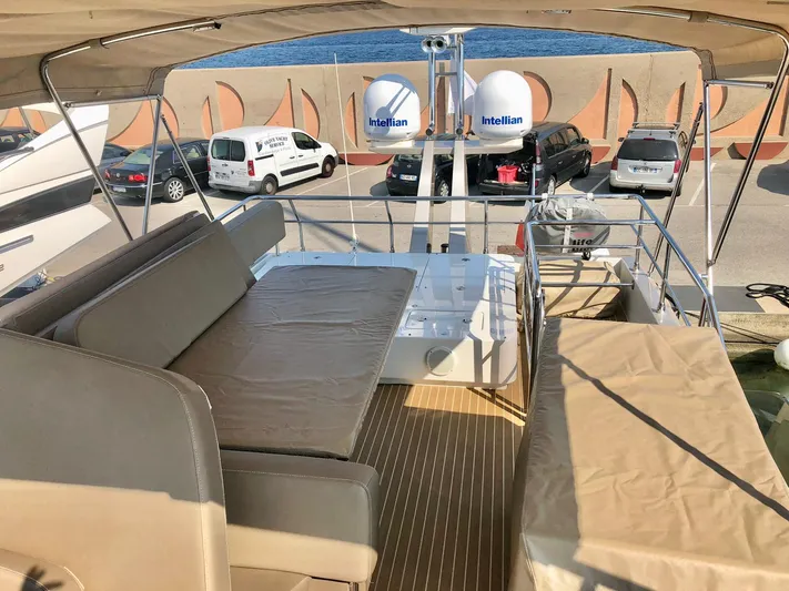  Yacht Photos Pics Flybridge of 2018 Guy Couach 1900 yacht with seating and parked vehicles in background.