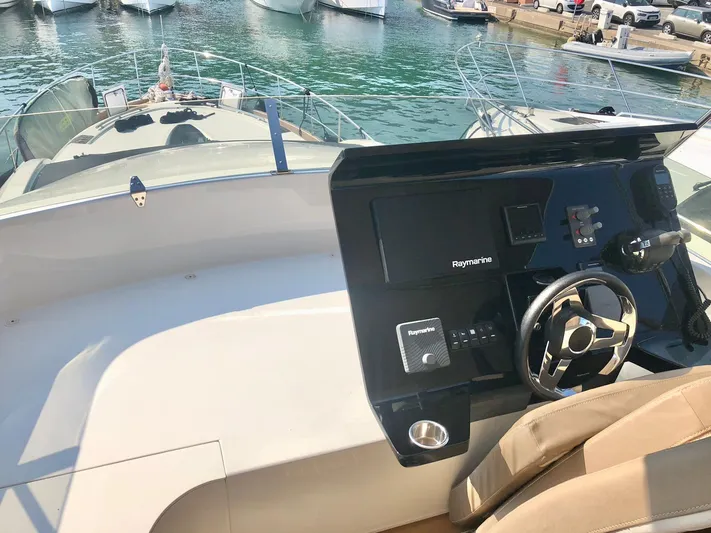  Yacht Photos Pics Helm of 2018 Guy Couach 1900 yacht with modern navigation equipment, docked at marina.