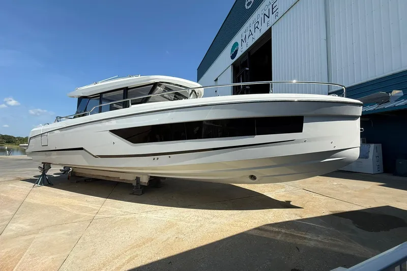  Yacht Photos Pics 2023 Wellcraft 355 boat displayed outside a marine facility under clear blue skies.