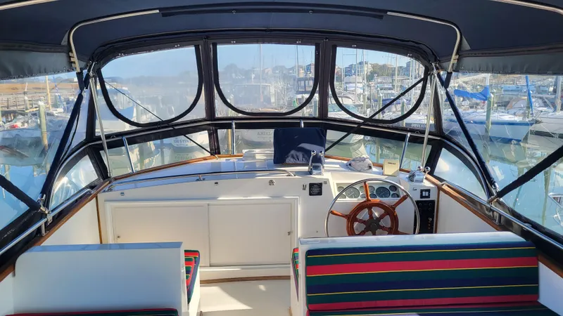 Maia Yacht Photos Pics Interior view of 1989 Grand Banks 42 Classic yacht with striped seating and wooden steering wheel.