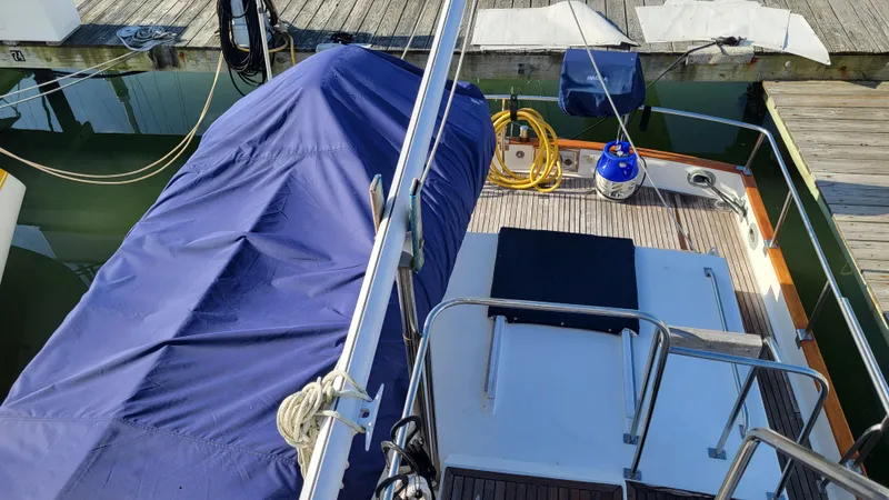 Maia Yacht Photos Pics 1989 Grand Banks 42 Classic yacht docked, covered with blue tarp, and equipped with deck gear.