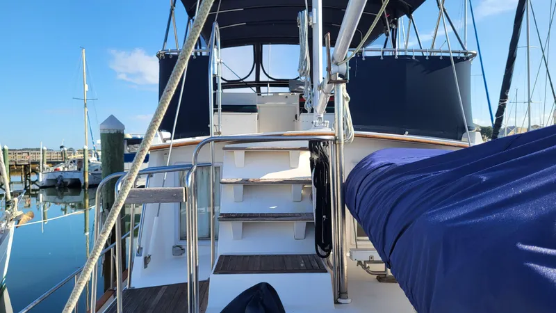 Maia Yacht Photos Pics 1989 Grand Banks 42 Classic yacht docked at marina, featuring blue canopy and polished railings.