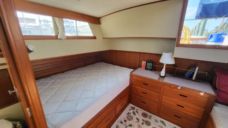 Maia Yacht Photos Pics Cozy bedroom in 1989 Grand Banks 42 Classic yacht with wooden furnishings and natural light.