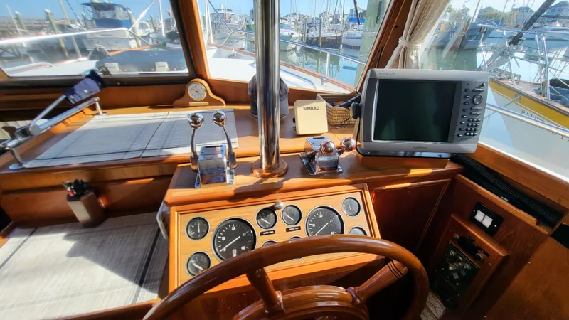 Maia Yacht Photos Pics Helm of 1989 Grand Banks 42 Classic yacht with navigation equipment and wooden steering wheel.