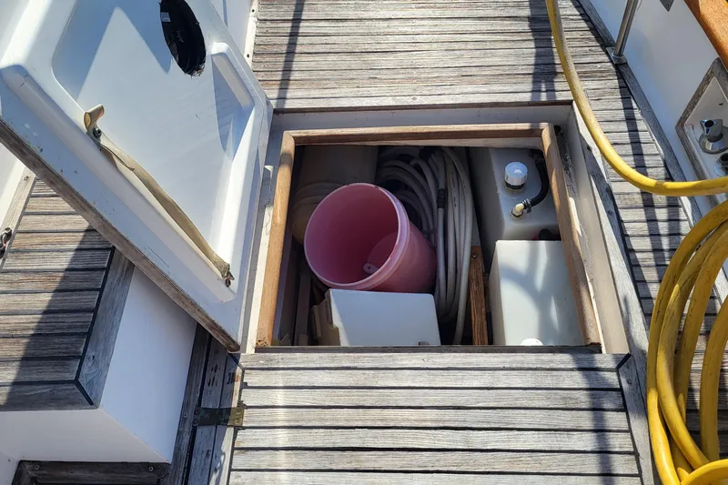 Maia Yacht Photos Pics Open storage compartment on 1989 Grand Banks 42 Classic boat deck with hoses and bucket.