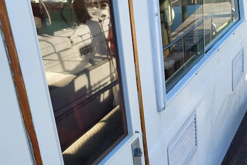 Maia Yacht Photos Pics Close-up of 1989 Grand Banks 42 Classic yacht exterior with reflections on windows.