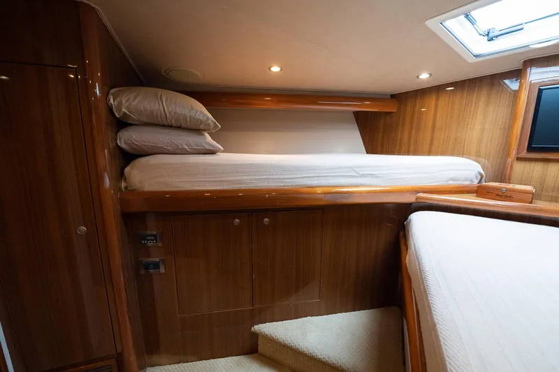 Defiance Yacht Photos Pics Luxurious 2007 Viking 64 Convertible yacht cabin with wooden interior and cozy bedding.