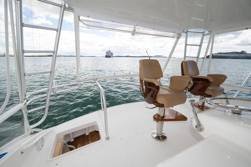 Defiance Yacht Photos Pics 2007 Viking 64 Convertible yacht deck with chairs, overlooking serene ocean view.