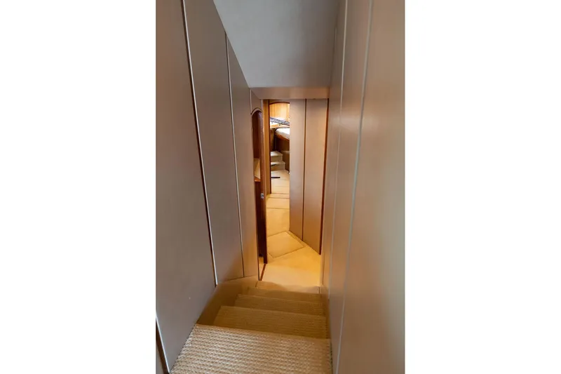 Defiance Yacht Photos Pics Interior hallway of 2007 Viking 64 Convertible yacht, featuring carpeted stairs and wooden door.