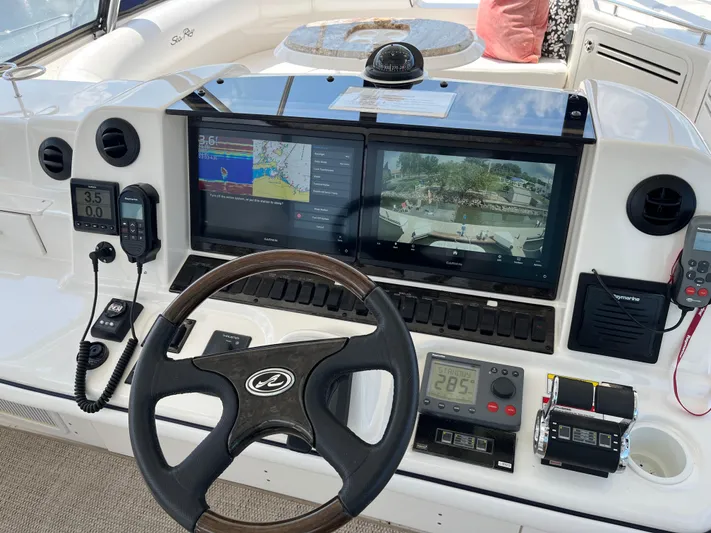  Yacht Photos Pics Control panel of a 2008 Sea Ray 58 Sedan yacht with navigation screens and steering wheel.