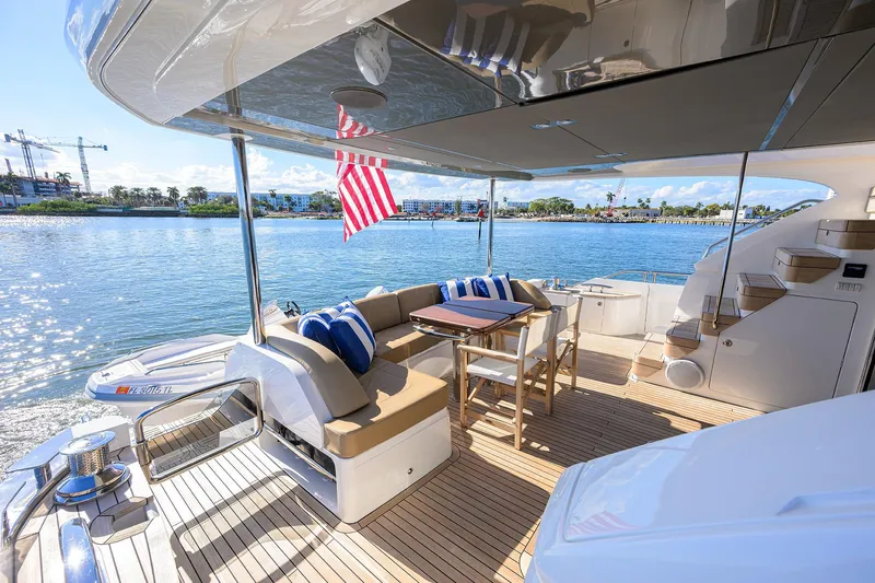 Janie II Yacht Photos Pics Luxurious 2021 Princess Y78 yacht deck with seating, table, and scenic waterfront view.