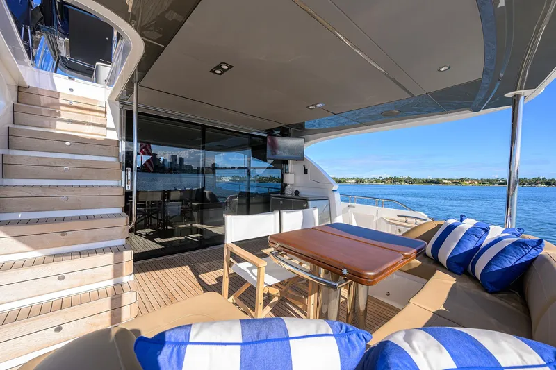 Janie II Yacht Photos Pics Luxurious 2021 Princess Y78 yacht deck with seating, table, and ocean view.
