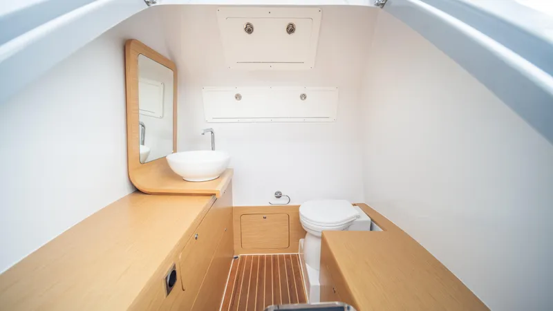 Skipper 38 Twin Mercury 400 V10 Verado Yacht Photos Pics Modern boat bathroom with wooden accents, featuring a sink and toilet. Skipper-BSK 38, 2025 model.
