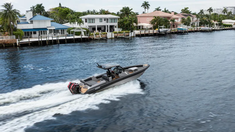 Skipper 38 Twin Mercury 400 V10 Verado Yacht Photos Pics 2025 Skipper-BSK 38 boat cruising on a scenic waterfront with luxury homes.