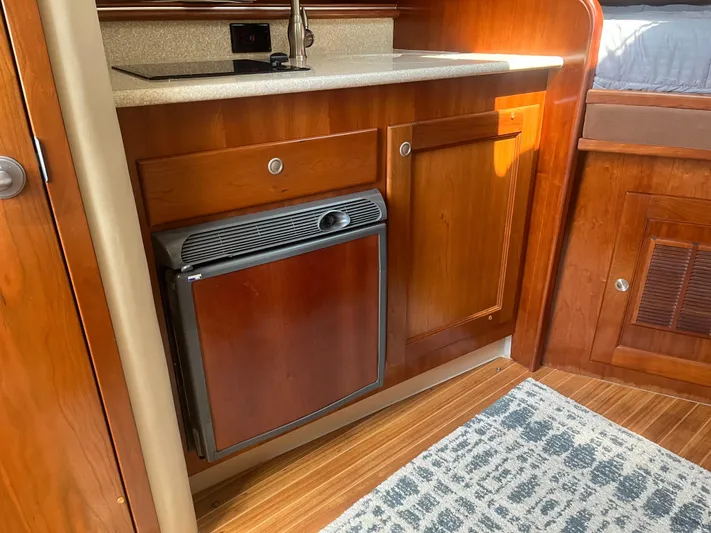  Yacht Photos Pics 2008 Rampage 30 Express boat interior with wooden cabinetry and compact kitchen area.