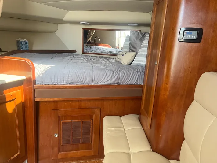  Yacht Photos Pics Interior of 2008 Rampage 30 Express boat with cozy bed and wooden cabinetry.