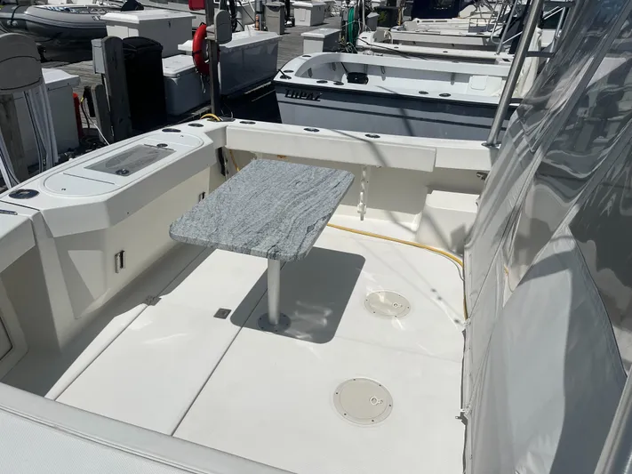  Yacht Photos Pics 2008 Rampage 30 Express boat deck with table, docked at marina.