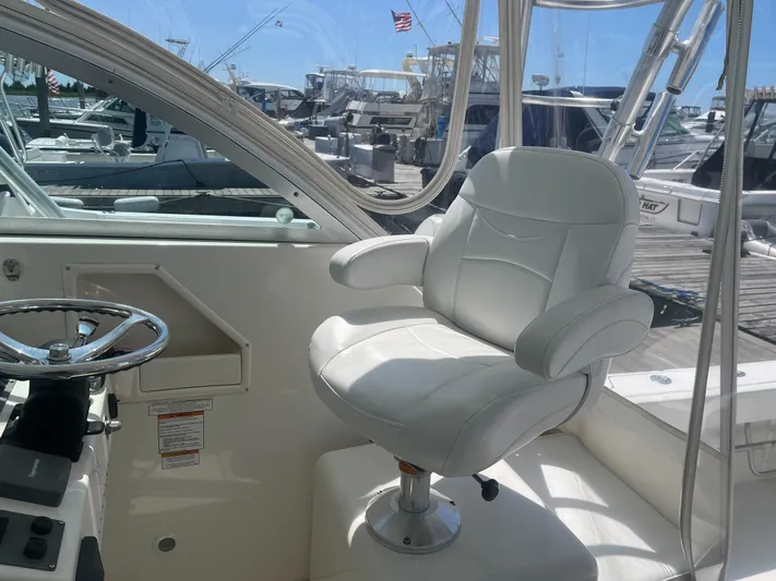  Yacht Photos Pics 2008 Rampage 30 Express boat helm with white captain's chair and steering wheel.