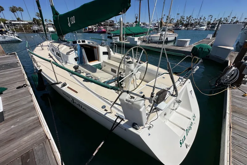 Ma Jolie Yacht Photos Pics 1996 J Boats J/120 sailboat docked in a marina, featuring green sail covers.
