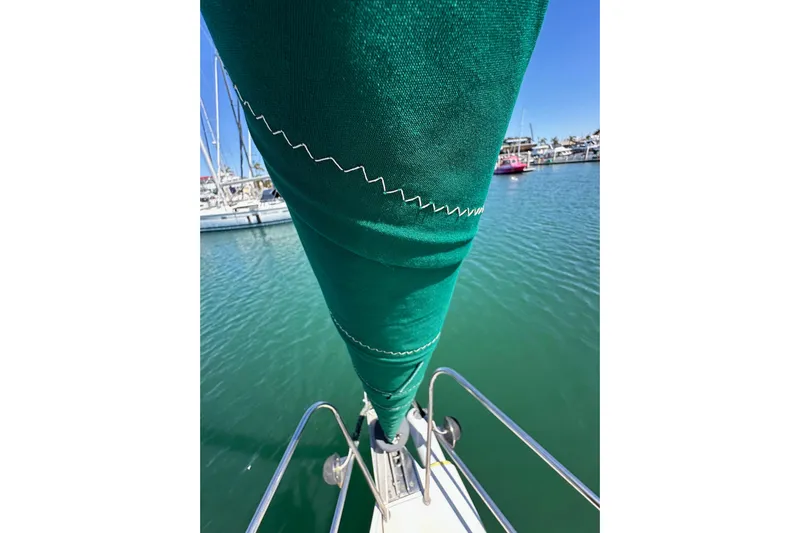 Ma Jolie Yacht Photos Pics Close-up of a green sail on a 1996 J Boats J/120 in a marina.