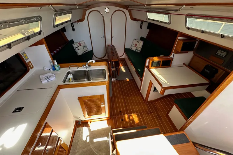 Ma Jolie Yacht Photos Pics Interior of 1996 J Boats J/120 sailboat with wood accents and compact kitchen area.