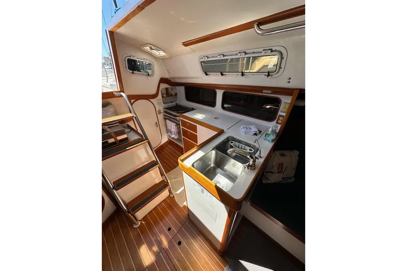 Ma Jolie Yacht Photos Pics Interior of 1996 J Boats J/120 sailboat with kitchen and wooden flooring.