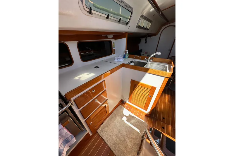Ma Jolie Yacht Photos Pics Interior of 1996 J Boats J/120 sailboat, featuring a wooden galley with sink and storage.