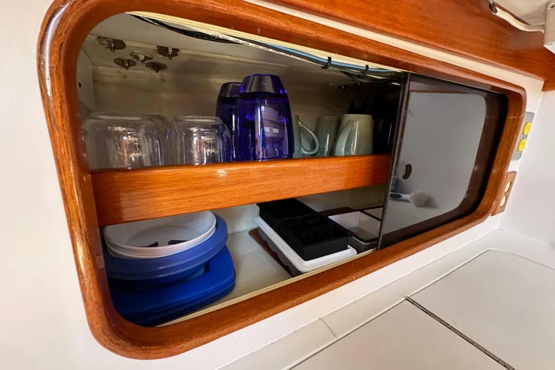 Ma Jolie Yacht Photos Pics Cabinet interior of 1996 J Boats J/120 with glasses and mugs neatly arranged.