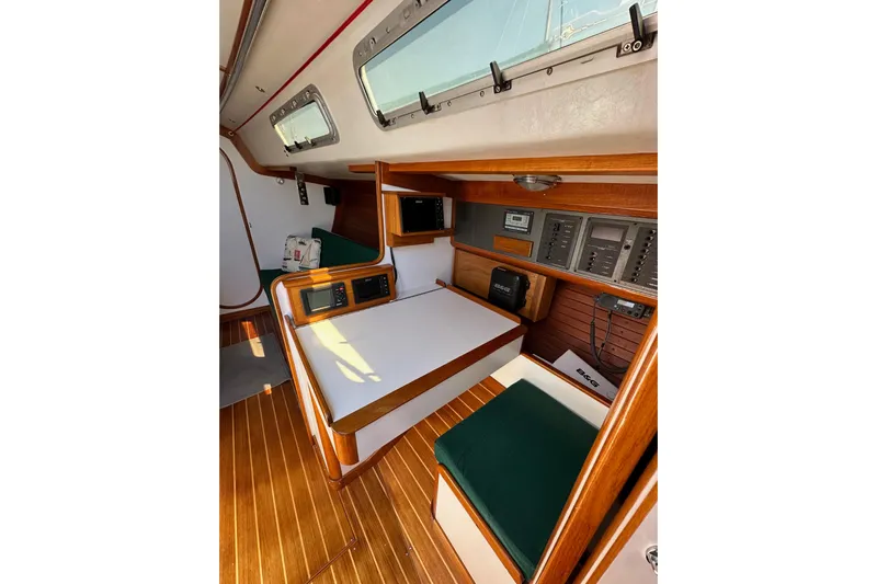 Ma Jolie Yacht Photos Pics 1996 J Boats J/120 interior with navigation station, wood finish, and green seating.