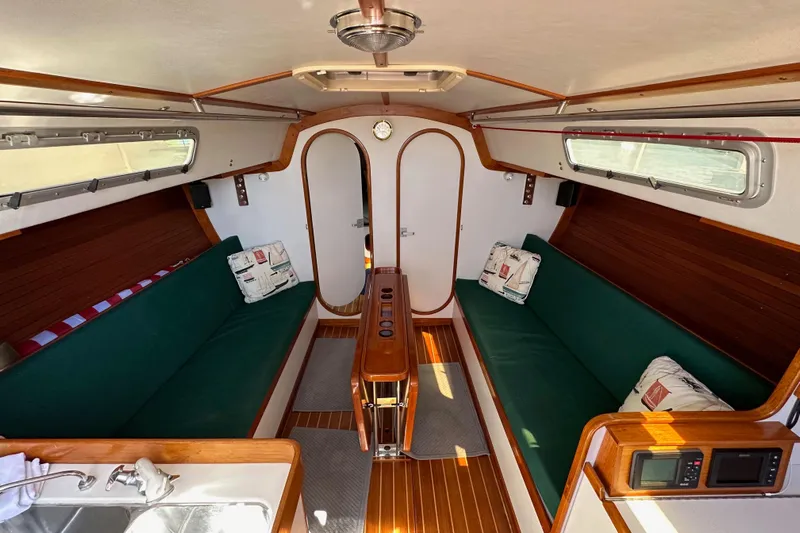 Ma Jolie Yacht Photos Pics Interior of 1996 J Boats J/120 sailboat with green seating and wood accents.