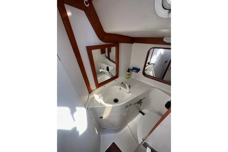 Ma Jolie Yacht Photos Pics Bathroom interior of 1996 J Boats J/120 yacht with sink, mirror, and toilet.
