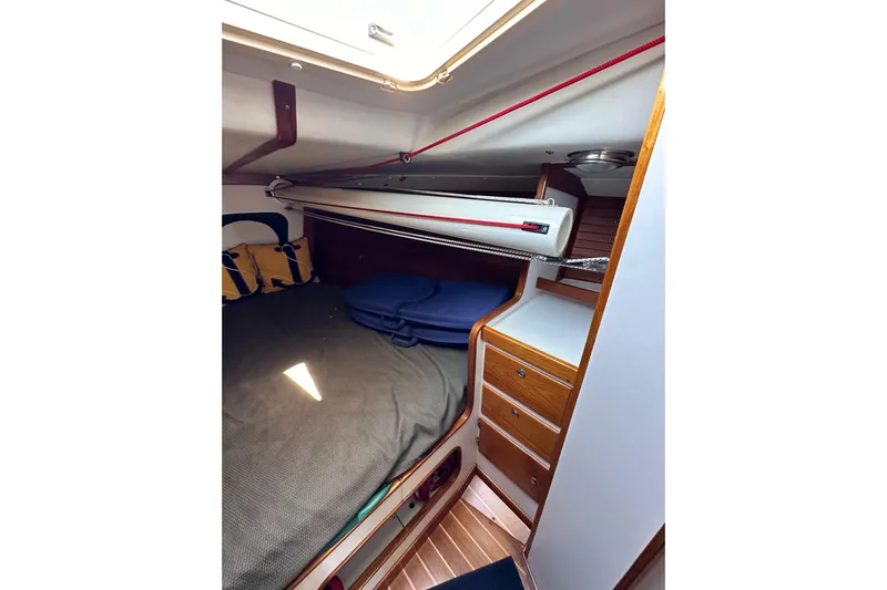 Ma Jolie Yacht Photos Pics Cozy cabin interior of 1996 J Boats J/120 with wooden drawers and bedding.