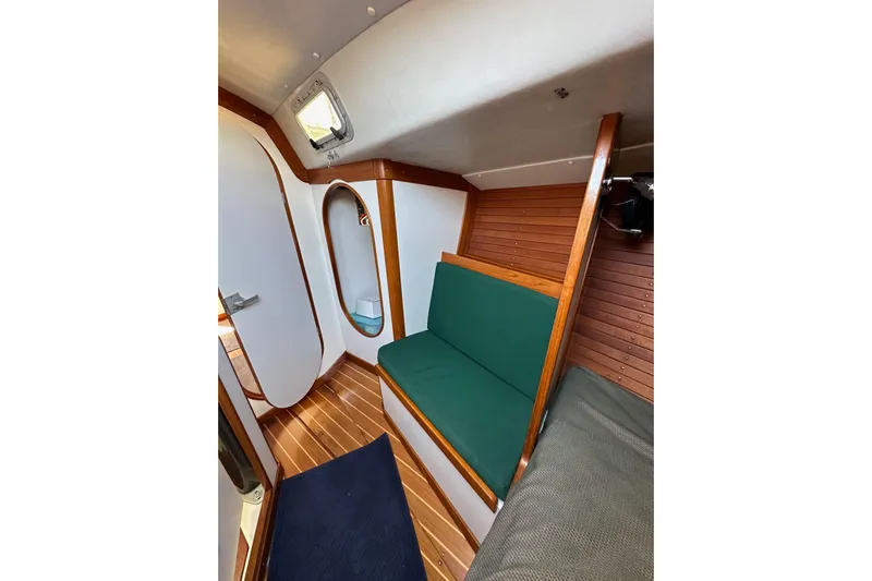 Ma Jolie Yacht Photos Pics Interior of 1996 J Boats J/120 sailboat with wooden paneling and green seating.