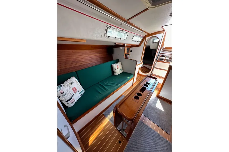 Ma Jolie Yacht Photos Pics Interior of 1996 J Boats J/120 sailboat with green seating and wooden accents.