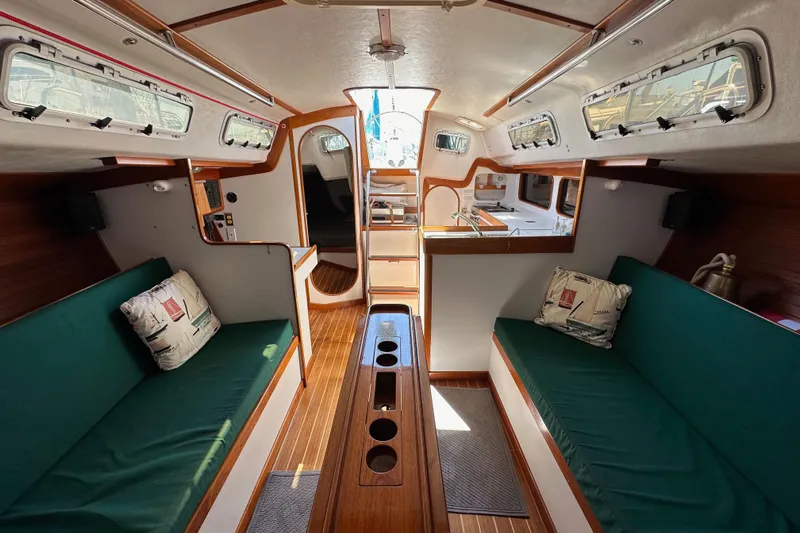 Ma Jolie Yacht Photos Pics Interior of 1996 J Boats J/120 sailboat with green seating and wooden accents.