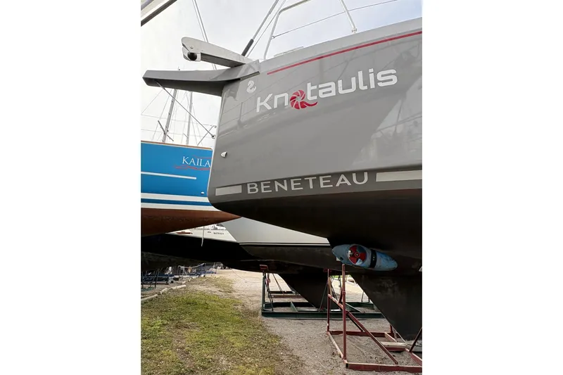 Knotaulis Yacht Photos Pics 2023 Beneteau Oceanis 34.1 sailboat on dry dock, showcasing hull and rudder.