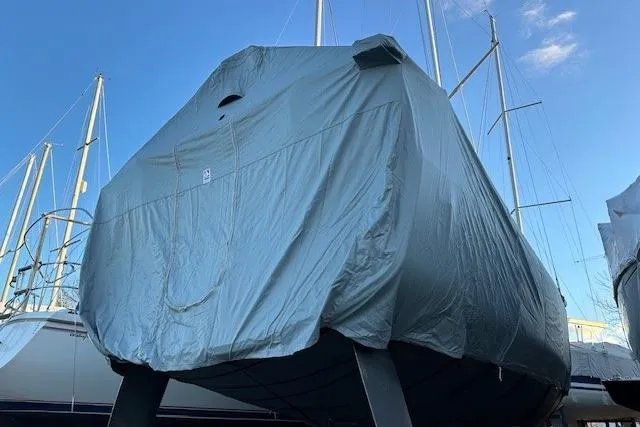 Knotaulis Yacht Photos Pics 2023 Beneteau Oceanis 34.1 sailboat covered, docked with masts visible.