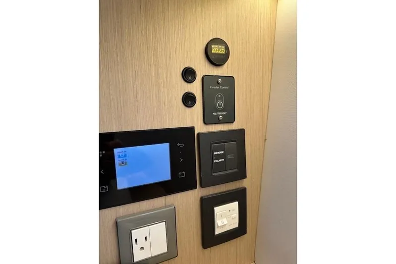 Knotaulis Yacht Photos Pics Control panel of 2023 Beneteau Oceanis 34.1 yacht with various switches and outlets.