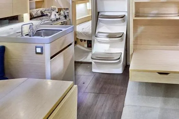 Knotaulis Yacht Photos Pics Interior of 2023 Beneteau Oceanis 34.1 yacht, featuring modern kitchen and cozy cabin space.