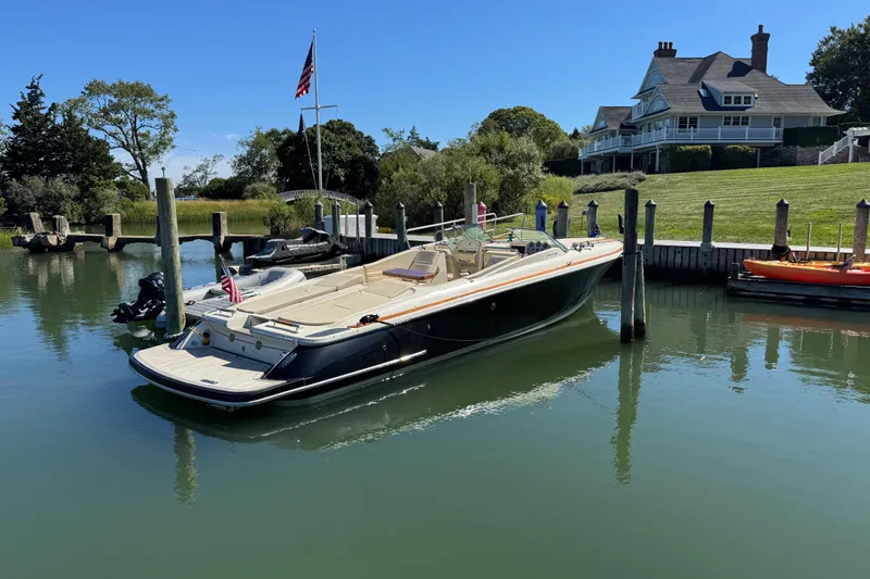  Yacht Photos Pics 2015 Chris-Craft Corsair 32 docked by a waterfront home, clear blue sky.