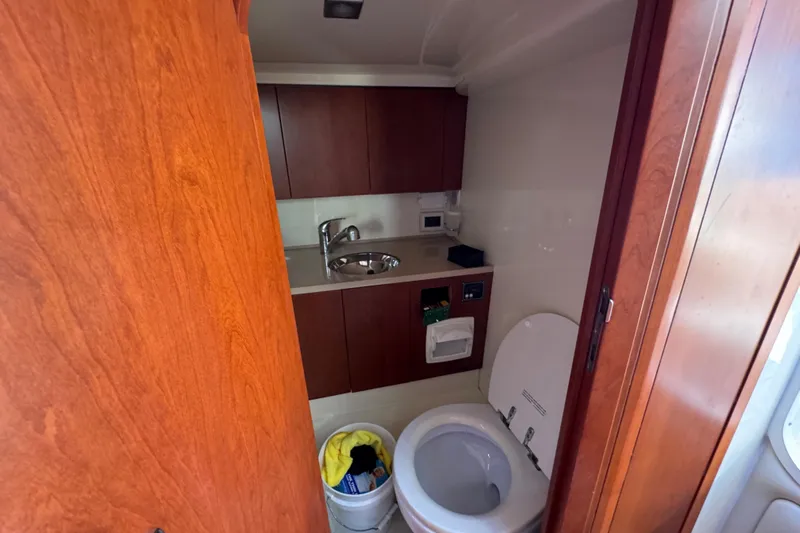  Yacht Photos Pics 2015 Chris-Craft Corsair 32 boat bathroom with wooden cabinetry and modern fixtures.