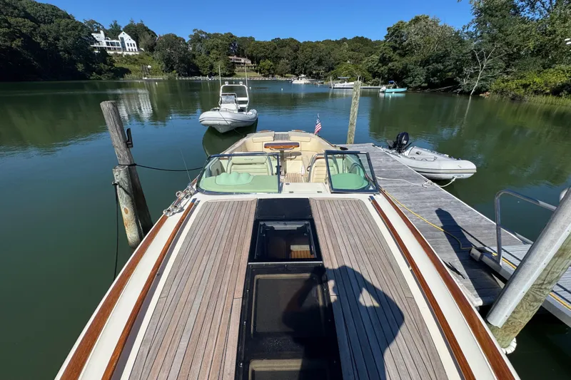  Yacht Photos Pics 2015 Chris-Craft Corsair 32 docked on a serene lake with lush surroundings.
