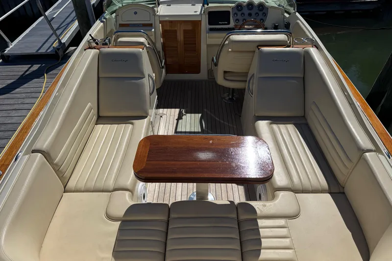  Yacht Photos Pics 2015 Chris-Craft Corsair 32 boat interior with beige seating and wooden table.