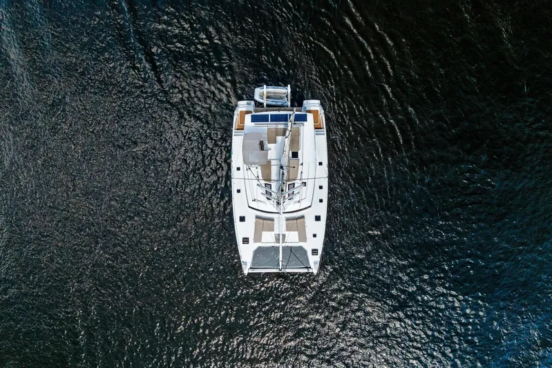 Serenity Yacht Photos Pics Overhead view of 2016 Fountaine Pajot SABA 50 catamaran on dark water.